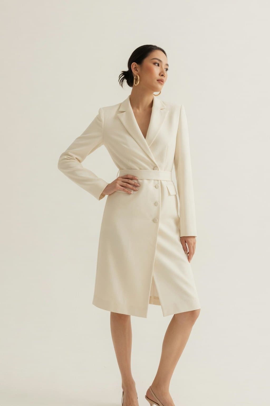 A cream belted shirt-dress photographed full length on a plain studio sweep - rendered by McLeuker AI