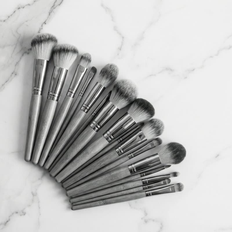 A fan of makeup brushes laid out on marble