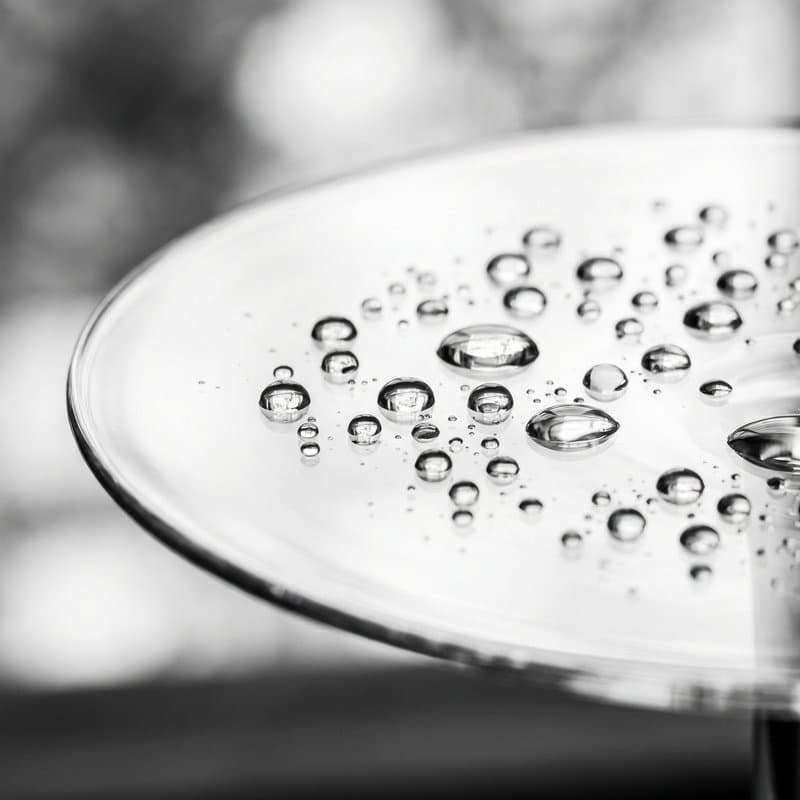 Serum droplets beaded across a clear glass dish
